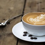 Cup of hot latte art coffee on wooden table