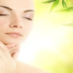 Beautiful young woman applying organic cosmetics to her skin